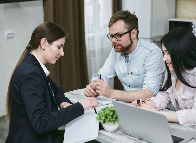 person looking over paperwork with a couple